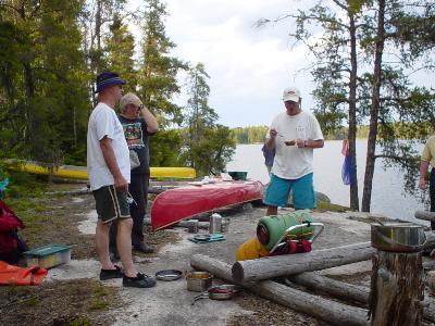 Don & Al visit with US fisherman while he devours smokies and beans.